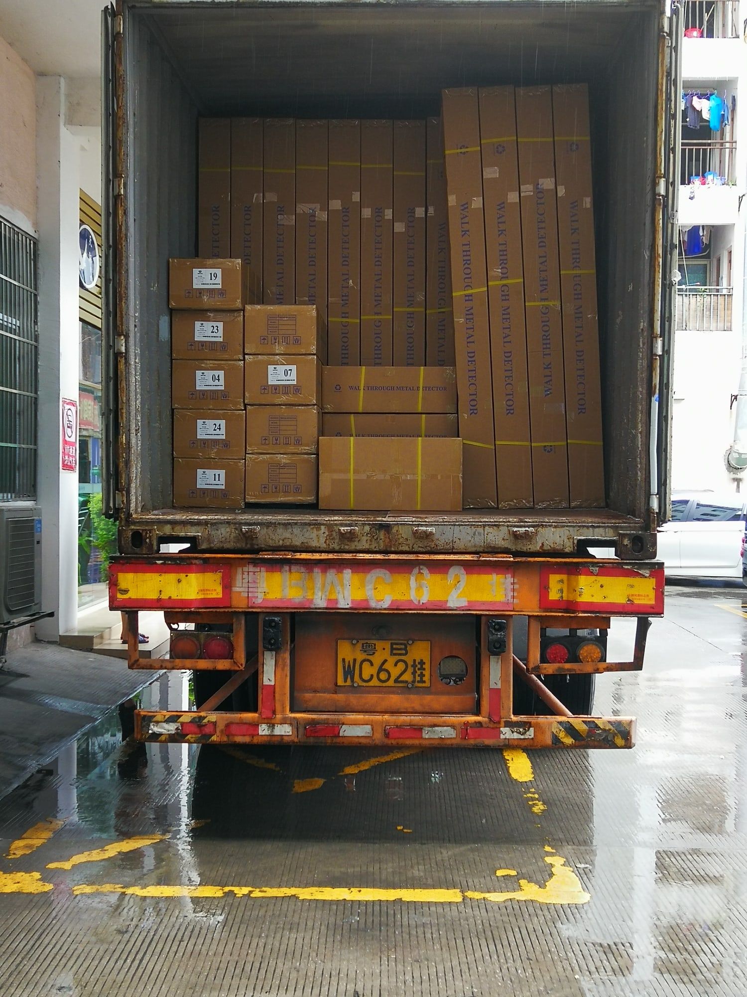 The open back of a container truck at a loading dock, stacked with cartons.